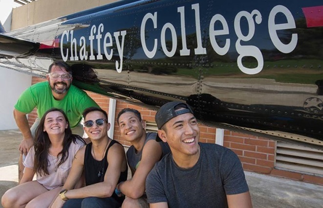 Five college students in front of Chaffey College sign.