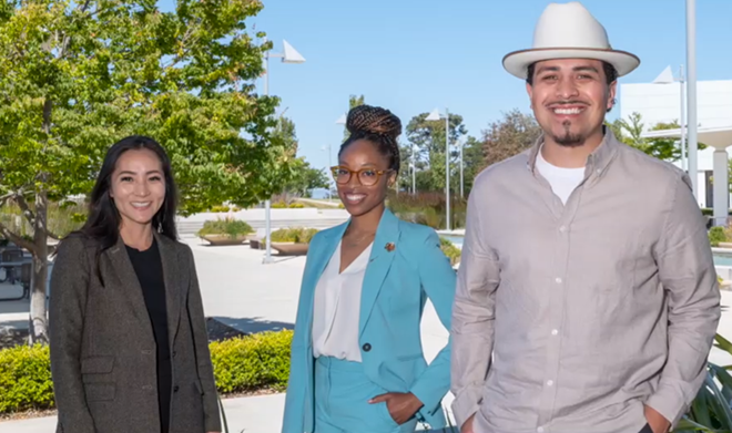 Three students facing camera smiling, outdoors