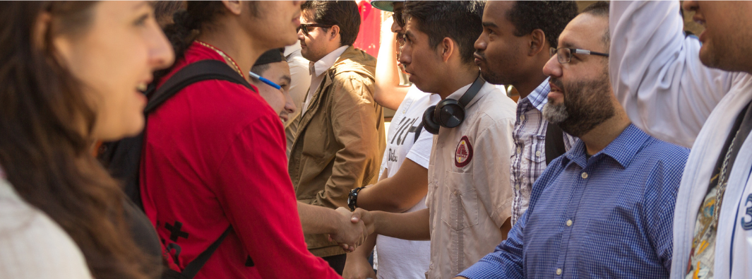 students shaking hands of other students and advisors