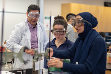Teacher and students wearing protective eye wear and working in a science lab