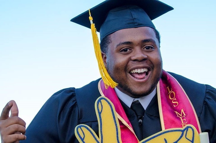 African American male student in graduation gown and cap smiling